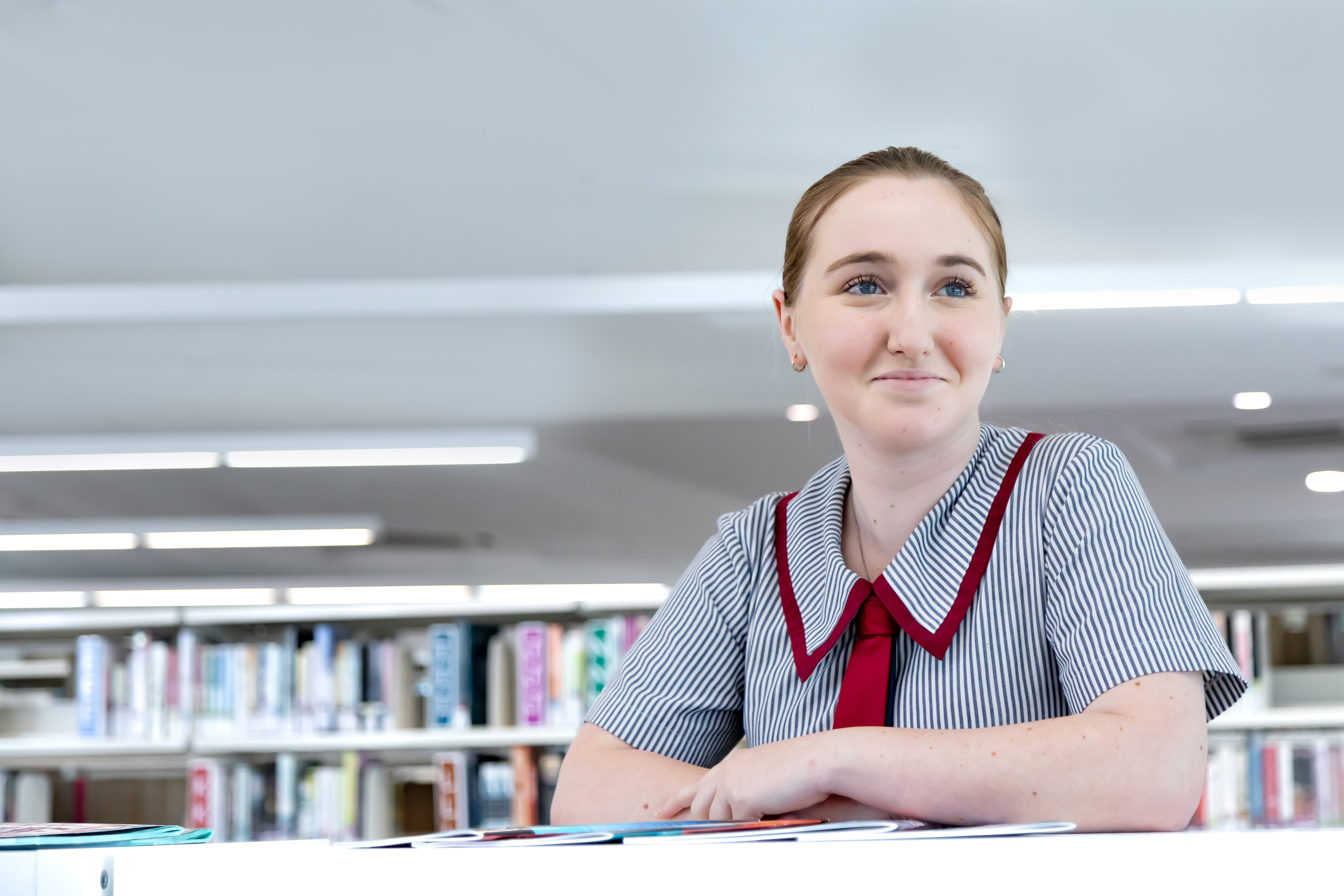 Student engaged in independent learning in a library setting at Carmel College Thornlands promoting focus responsibility and academic growth